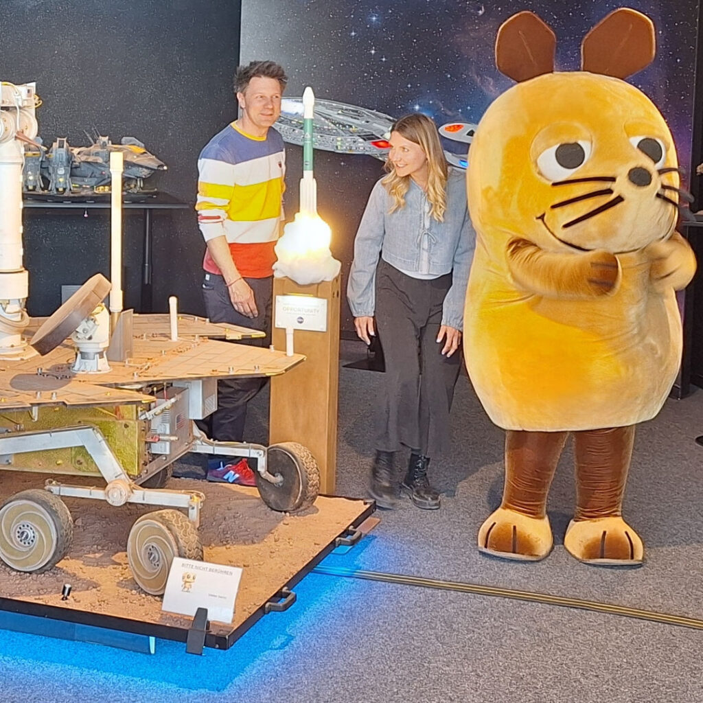 Die Maus-Moderatoren Jana Forkel und André Gatzke haben zusammen mit der Maus Szenen für einen Trailer zur Aktion "Türen auf mit der Maus" gedreht.